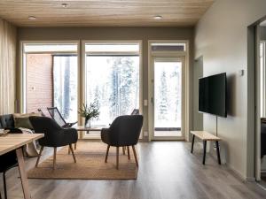 ein Wohnzimmer mit Tisch und Stühlen und Fenstern in der Unterkunft Holiday Home Vuokatin loiste 9 a 3 by Interhome in Vuokatti