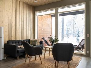 ein Wohnzimmer mit Couch und Stühlen in der Unterkunft Holiday Home Vuokatin loiste 9 a 3 by Interhome in Vuokatti