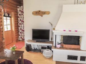 Una sala de estar con televisión y chimenea. en Holiday Home Käpälysmökki by Interhome, en Nurmes 12 fotos más