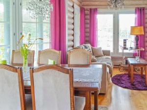 comedor con mesa y cortinas rosas en Holiday Home Käpälysmökki by Interhome, en Nurmes