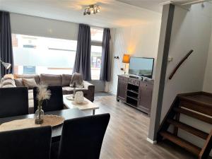 een woonkamer met een bank en een televisie bij Holiday Home Brouwershaven by Interhome in Brouwershaven