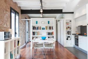 a kitchen with a white table and white shelves at AB Paral-lel Tapioles in Barcelona