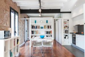 a kitchen with a white table and white shelves at AB Paral·lel Apartments in Barcelona