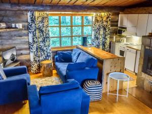 a living room with a blue couch and a table at Holiday Home Kelosyväri 17 by Interhome in Nilsiä