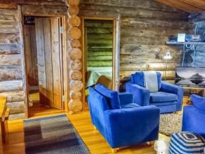 un salon avec des chaises bleues et une chambre dans l'établissement Holiday Home Kelosyväri 17 by Interhome, à Nilsiä