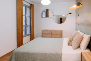 Un dormitorio con una cama blanca con almohadas y una ventana en Superbe T2 neuf Bonifacio avec parking gratuit en Bonifacio
