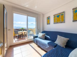 a living room with a blue couch and a balcony at Apartment Lomas del Mar V-2 by Interhome in Playas de Vera