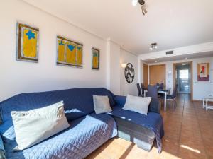 a living room with a blue couch and a dining room at Apartment Lomas del Mar V-2 by Interhome in Playas de Vera +17 photos