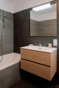 a bathroom with a sink and a mirror and a tub at Superbe T2 neuf Bonifacio avec parking gratuit in Bonifacio