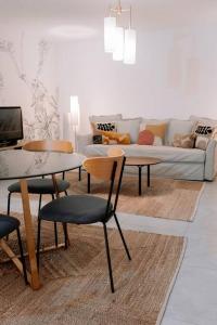 a living room with a couch and a table and chairs at Superbe T2 neuf Bonifacio avec parking gratuit in Bonifacio