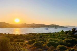 un coucher de soleil sur une étendue d'eau avec des bateaux dans l'établissement Villino con vista mare e piscina, à Palau