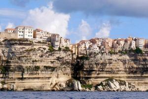 un groupe de bâtiments au sommet d'une montagne rocheuse dans l'établissement Superbe T2 neuf Bonifacio avec parking gratuit, à Bonifacio