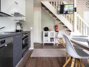 a kitchen with a table and chairs and a staircase at Holiday Home Himoksen keiju 1 by Interhome in Jämsä