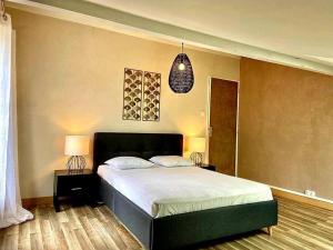 a bedroom with a large bed and a pendant light at Cosy au calme, climatisation, 3min A41 in Bernin
