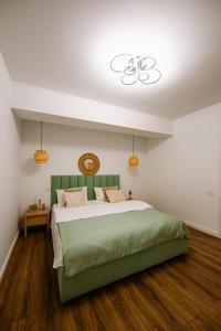 a bedroom with a large green bed with a ceiling at Mountain View with Terrace in Sinaia