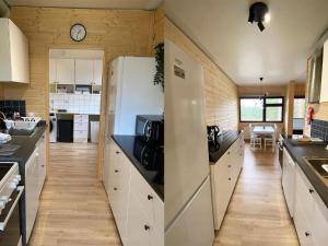 a kitchen with white cabinets and a white refrigerator at Holiday Home The cozy loggers suite by Interhome in Salla