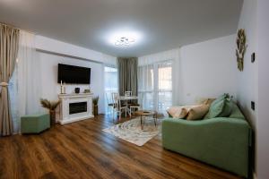 a living room with a green couch and a fireplace at Mountain View with Terrace in Sinaia