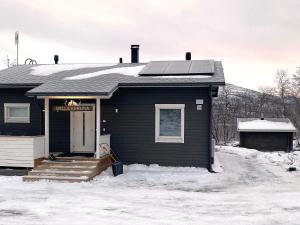 una casa negra con nieve en el suelo en Holiday Home Willa kiiruna by Interhome en Kilpisjärvi