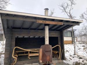 a out house with a stove in the snow at Holiday Home Willa kiiruna by Interhome in Kilpisjärvi