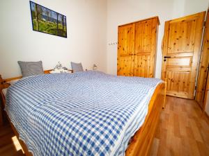 ein Schlafzimmer mit einem Bett und zwei Holztüren in der Unterkunft Holiday Home Ferienhaus Bude 87 by Interhome in Bad Arolsen