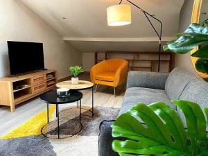a living room with a couch and a tv at Cosy au calme, climatisation, 3min A41 in Bernin