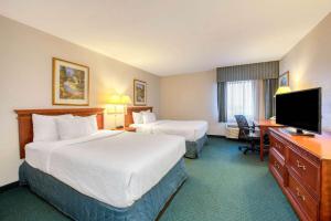 a hotel room with two beds and a flat screen tv at La Quinta Inn by Wyndham Cleveland Independence in Independence