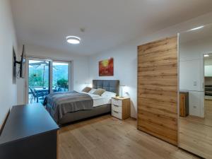 a bedroom with a bed and a wooden sliding door at Apartment Terrace 04 alpe maritima Ski & See-Top 4 by Interhome in Annenheim