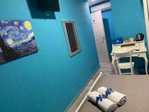Zimmer mit blauer Wand und Handtüchern auf dem Bett in der Unterkunft Residenza Manfredi in Potenza