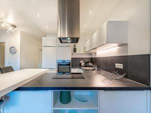 a kitchen with white cabinets and blue appliances at Apartment Berg- und Seeblick alpe maritima -Top 10 by Interhome in Annenheim