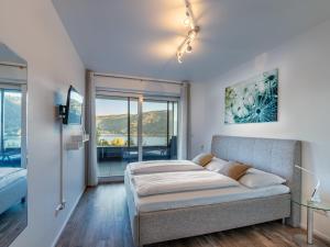 a bedroom with a bed and a balcony at Apartment Berg- und Seeblick alpe maritima -Top 10 by Interhome in Annenheim