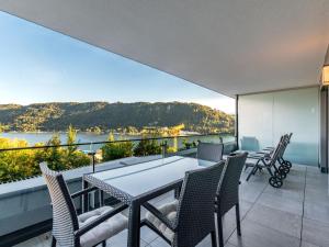 a dining room with a table and chairs on a balcony at Apartment Berg- und Seeblick alpe maritima -Top 10 by Interhome in Annenheim