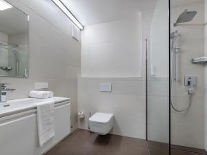 a white bathroom with a toilet and a shower at Apartment Grosse Freiheit alpe maritima Ski&See-17 by Interhome in Annenheim