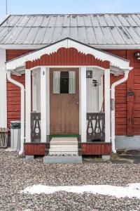 a red and white house with a wooden door at Chalet Norrskensstugan - NBO010 by Interhome in Vidsel