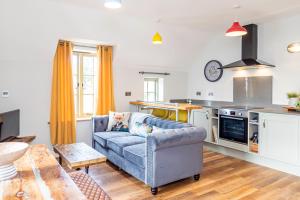 ein Wohnzimmer mit einem Sofa und einer Küche in der Unterkunft Cosy House Free Driveway Parking Good Location in New Bilton