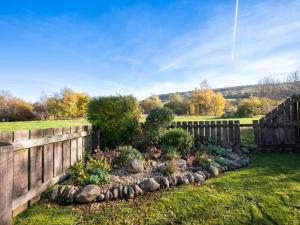 un jardín frente a una valla de madera en Holiday Home Glenloch Cottage by Interhome, en Drumnadrochit