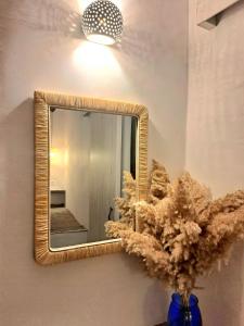 a mirror on a wall with a plant in a vase at Aegean Serenity - Sea View Retreat in Archangelos