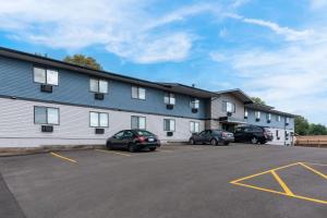 een gebouw met auto's geparkeerd op een parkeerplaats bij Econo Lodge in Madison