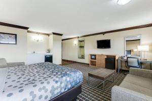 um quarto de hotel com uma cama e uma secretária em Econo Lodge em Madison