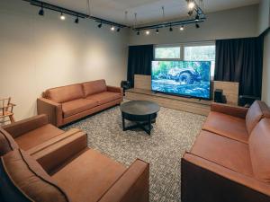 ein Wohnzimmer mit Sofas und einem Flachbild-TV in der Unterkunft Holiday Home Ruokolan kartano by Interhome in Sotkamo