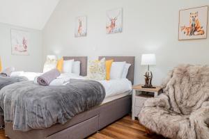 1 Schlafzimmer mit 2 Betten und einem Stuhl in der Unterkunft Cosy House Free Driveway Parking Good Location in New Bilton