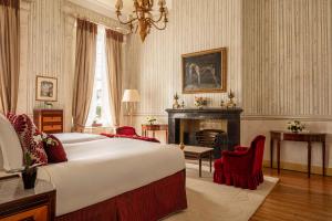 a bedroom with a large bed and a fireplace at Tivoli Palácio de Seteais Sintra Hotel - The Leading Hotels of the World in Sintra
