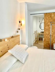 - une chambre avec un grand lit blanc et un miroir dans l'établissement Loft Alameda en Sevilla, à Séville
