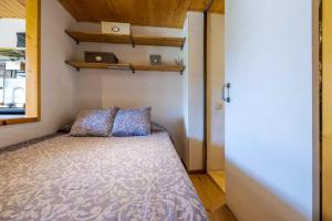 Habitación pequeña con cama y ventana en Enmolinate, en La Molina