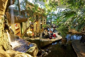 a group of people sitting in a building with a waterfall at Center Parcs Huttenheugte Drenthe-Overijssel in Dalen