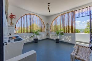 een kamer met drie grote ramen met planten erin bij Fully Furnished 2 Bedroom Apartment along Diani Beach Road in Diani Beach