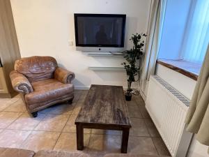 a living room with a chair and a television at Tregib Mill Cottage in Ffair-fâch