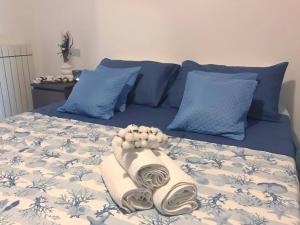 ein Bett mit blauen Kissen und einem Handtuch darauf in der Unterkunft Casa Anima 7 - Citra 011001-LT-0178 in Ameglia