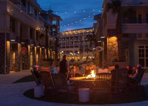 a group of people sitting around a fire in a courtyard at Wild Dunes Resort - Residences at Sweetgrass in Isle of Palms