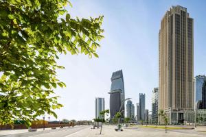 un perfil urbano con rascacielos altos en Wyndham Grand Doha West Bay Beach, en Doha