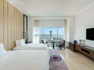 a hotel room with two beds and a flat screen tv at Rixos Marina Abu Dhabi in Abu Dhabi